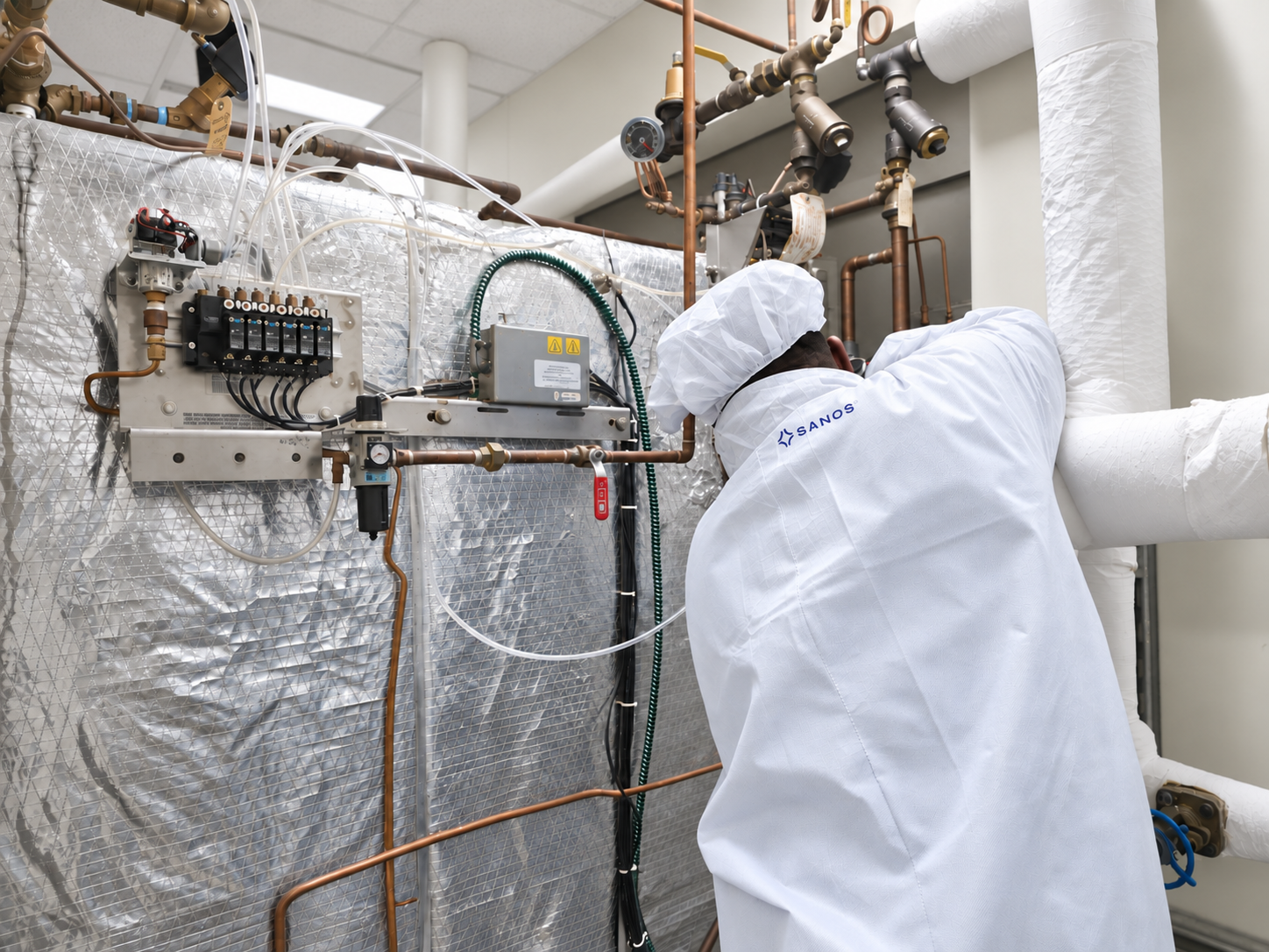 Sanos technician servicing the piping and controls of a steam sterilizer