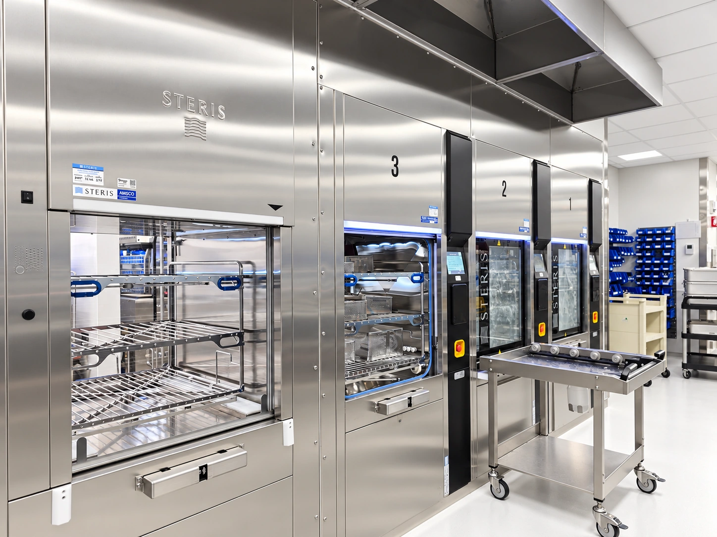 STERIS washer-disinfectors with open instrument racks and a loading trolley